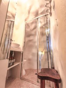 a shower with a wooden chair in front of a mirror at Gîte du rempart avec Balnéo, Garage, 2 SDB 2WC vue sur les monuments in Le Puy-en-Velay