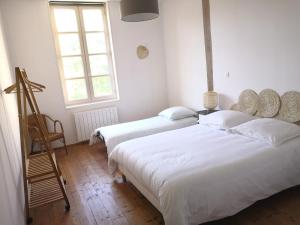 a bedroom with two beds and a ladder and two windows at Maison de charme spacieuse, terrasse et vue sur la place in Monflanquin