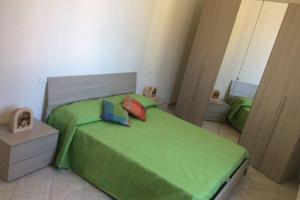 una camera con un letto verde con due cuscini di Ca' Rosetta Your home near Cinque Terre & Versilia ad Arcola