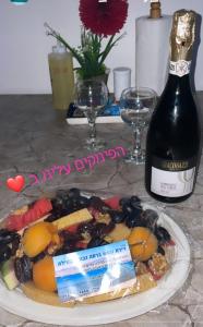 a plate of food and a bottle of wine on a table at דירות נופש וג'קוזי באילת - אילן vip in Eilat