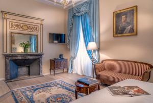 a living room with a couch and a fireplace at Palazzo Cavagna Sangiuliani in Bereguardo