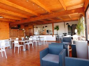 a restaurant with wooden ceilings and tables and chairs at Villa Raggio di Sole parcheggio privato in Porto Cesareo