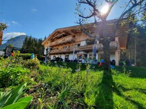 a wooden house with the sun shining on it at Landhaus Knaus in Leutasch