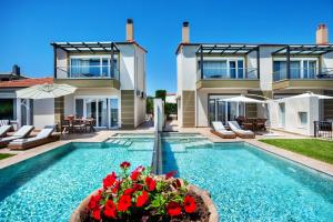 eine Villa mit einem Pool und einem Haus in der Unterkunft Sunny Villas Resort & Spa in Chaniotis