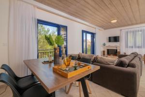 a living room with a table and a couch at Armiriki Holiday Home in Agios Nikolaos