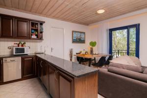 una cucina e un soggiorno con divano e tavolo di Armiriki Holiday Home a Agios Nikolaos