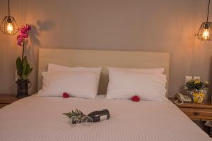 a bed with a pair of glasses and flowers on it at Filoxenia Hotel in Volos