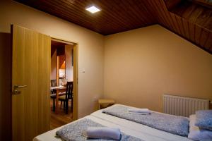 1 dormitorio con 2 camas y comedor en Natúra Panzió&Apartmanház en Orfű