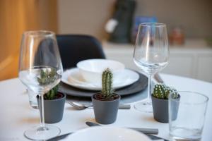 a table with three wine glasses and cactuses on it at COSY LIVING in Huningue