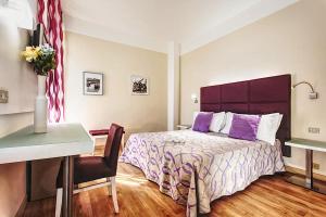 a bedroom with a bed and a table and a desk at Hotel Spiaggia in Gatteo a Mare