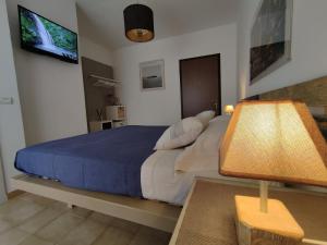 een slaapkamer met een groot bed en een blauwe deken bij Civico10 Polignano in Polignano a Mare