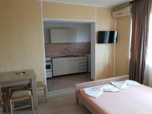 Zimmer mit einem Bett und einem Tisch sowie einer Küche in der Unterkunft Apartments Popovic in Ulcinj