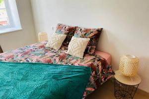 - une chambre avec un lit et une couette colorée dans l'établissement La roseraie de L arguenon, spacieux appartement centre ville, à Jugon Les Lacs