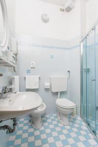 La salle de bains blanche est pourvue d'un lavabo et de toilettes. dans l'établissement Hotel Spiaggia, à Gatteo a Mare