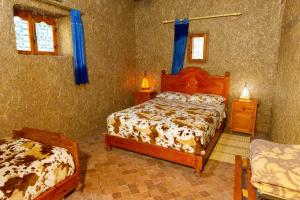 - une chambre avec 2 lits et 2 tables de chevet dans l'établissement Maison Nomades, à Aït Boukha