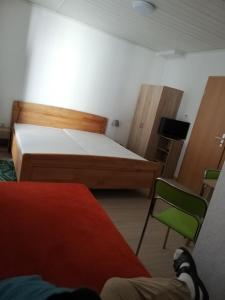 um quarto com 2 camas e uma cadeira verde em Gasthaus Zur Traube em Hatzenport