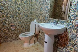 a bathroom with a toilet and a sink at Maison Nomades in Tighmert