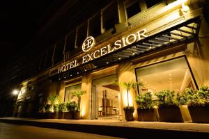 Hotel Excelsior Karachi في كراتشي: شكل الفندق الخارجي في الليل مع وجود لافته عليه