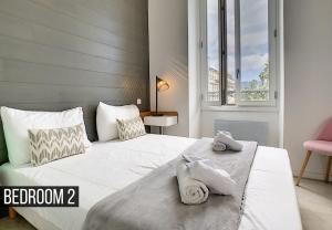 a bedroom with a large white bed with towels on it at Nestor&Jeeves - ALBERT 1ER DESIGN - Hyper center - Very close sea and pedestrian zone in Nice