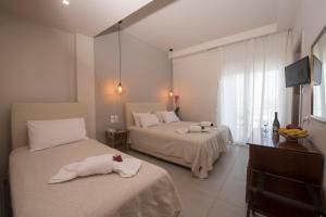 a hotel room with two beds with towels on them at Filoxenia Hotel in Volos