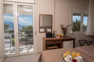 a bedroom with a bed and a desk with a mirror at Filoxenia Hotel in Volos