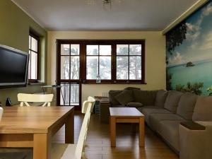 a living room with a couch and a table at Apartament Hania - Krynica Morska in Krynica Morska