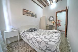 a white bedroom with a bed and a mirror at Residenza Briati in Venice