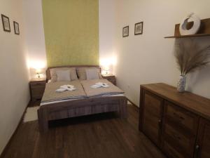 ein Schlafzimmer mit einem Bett mit zwei Handtüchern darauf in der Unterkunft Dolina Apartman in Eger
