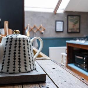 Blackshaw's Studio في Scolboa: غلاية الشاي موجودة فوق طاولة خشبية