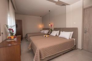 a hotel room with two beds and a table at Filoxenia Hotel in Volos
