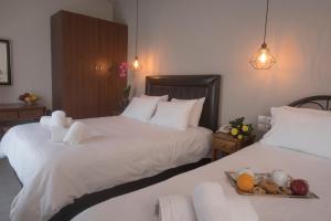 two beds in a hotel room with a tray of food at Filoxenia Hotel in Volos