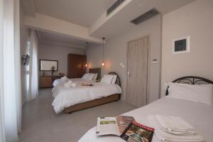 a hotel room with two beds and a table at Filoxenia Hotel in Volos