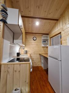 eine Küche mit einem weißen Kühlschrank und einer Spüle in der Unterkunft Siedlisko nr 4A nad jeziorem Skarlińskim, jezioro, mazury, domki letniskowe in Kurzętnik