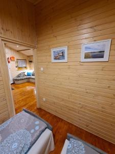 ein Zimmer mit Holzwänden und ein Schlafzimmer mit 2 Betten in der Unterkunft Siedlisko nr 4A nad jeziorem Skarlińskim, jezioro, mazury, domki letniskowe in Kurzętnik