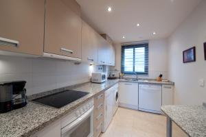 een keuken met witte kasten en een aanrecht bij Exclusivo apartamento 2 dormitorios in Torrox Costa