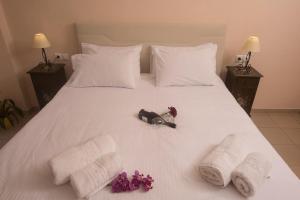 a white bed with towels and teddy bears on it at Filoxenia Hotel in Volos