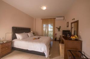 a bedroom with a bed and a dresser with a television at Filoxenia Hotel in Volos