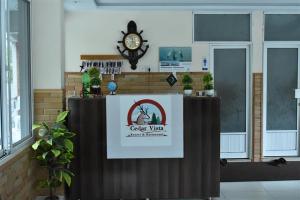 a table with a sign and a clock on a wall at Cedar Vista Resort in Kāgān