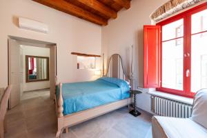 una camera con un letto in una stanza con finestre rosse di DOMO SOFIA a Cagliari