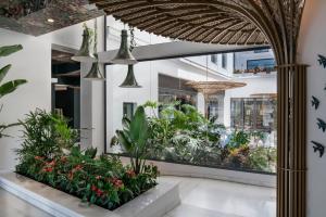 a lobby with plants and a large window at Vincci Selección Posada del Patio in Málaga