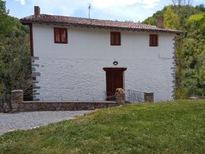 a white house with a door on a hill at Molino De Pradillo in Pradillo