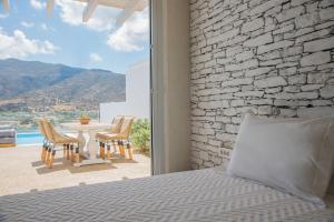 a bedroom with a bed and a table and chairs at Levantes Ios Boutique Hotel in Mylopotas