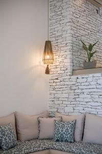 a living room with a couch and a brick wall at Levantes Ios Boutique Hotel in Mylopotas