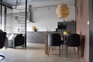a kitchen with a dining room table and black chairs at Dock Hotel Stellendam in Stellendam