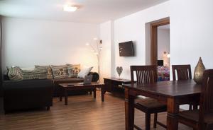 a living room with a table and a couch at Penzion Malina in Hronská Dúbrava
