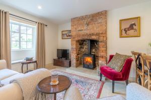 a living room with a couch and a fireplace at Poppy Cottage in Broadwell