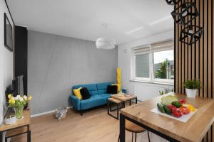 a living room with a blue couch and a table at Otwock PREMIUM Apartment- CENTRUM PKP in Otwock