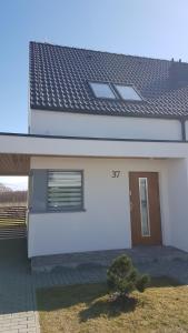 a white house with a window and a door at Garden Baltic in Trzęsacz