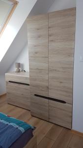 トシェンサチにあるGarden Balticのベッドルーム(大型の木製ドレッサー、ベッド1台付)