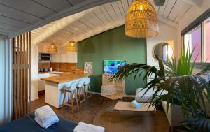 eine Küche und ein Wohnzimmer mit einem Tisch und einer Theke in der Unterkunft sous les toits de st tropez in Saint-Tropez